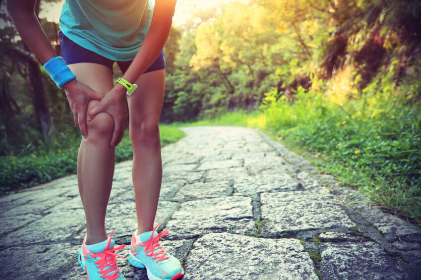 Woman experiencing knee pain while doing cardio