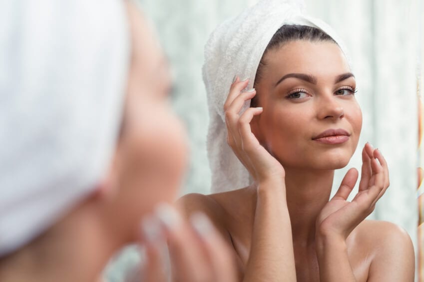 Woman looking her reflection in a mirror