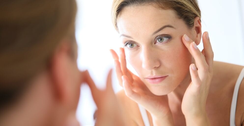 Woman looking her reflection in a mirror